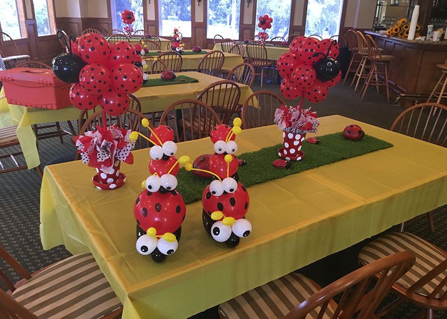A table decorated with ladybugs and balloons for a birthday party.