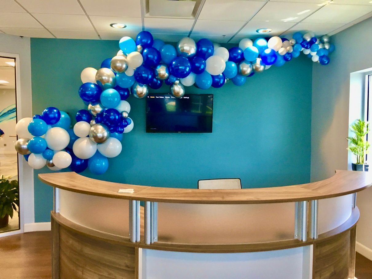 A reception area decorated with blue , white and silver balloons.