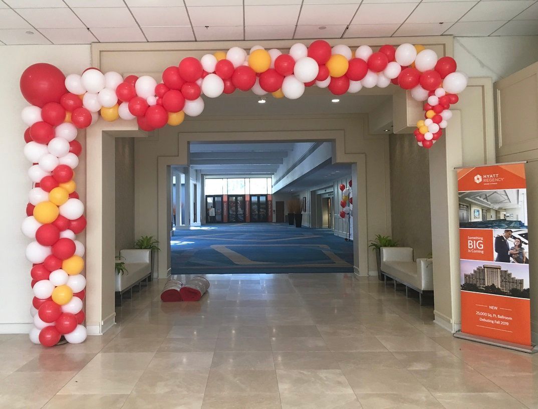 A hallway with red white and yellow balloons