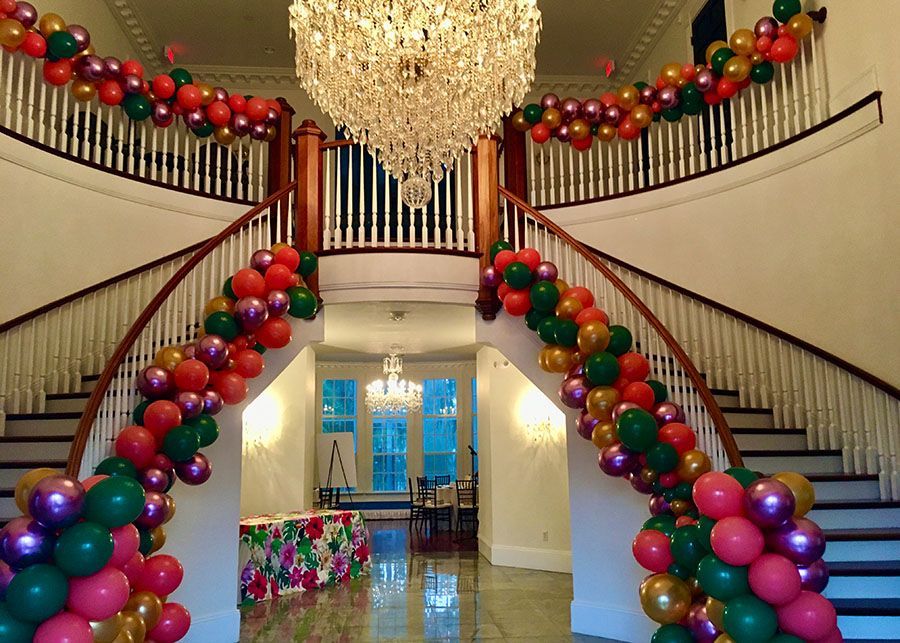 A staircase decorated with balloons and a chandelier.