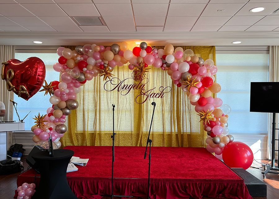 A stage decorated with balloons and a heart shaped balloon.