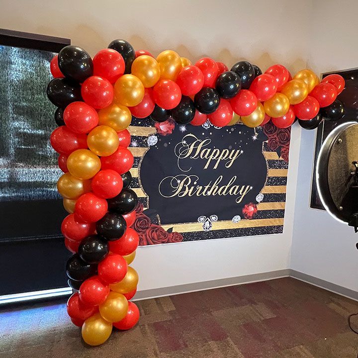 A room with balloons and a sign that says happy birthday