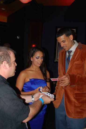 A woman in a blue dress is standing next to a man in an orange jacket