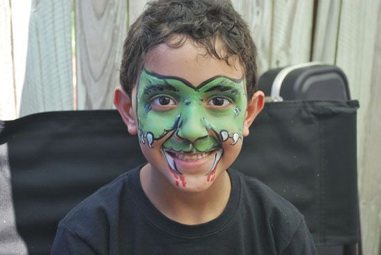 A young boy with his face painted like a monster