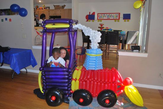 A train made out of balloons in a living room