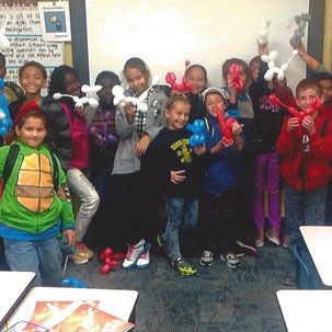 A group of children are posing for a picture with balloons in their hands