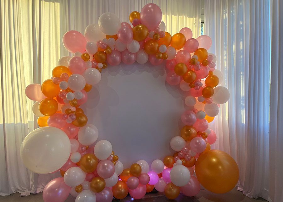 A room filled with balloons and a white curtain.
