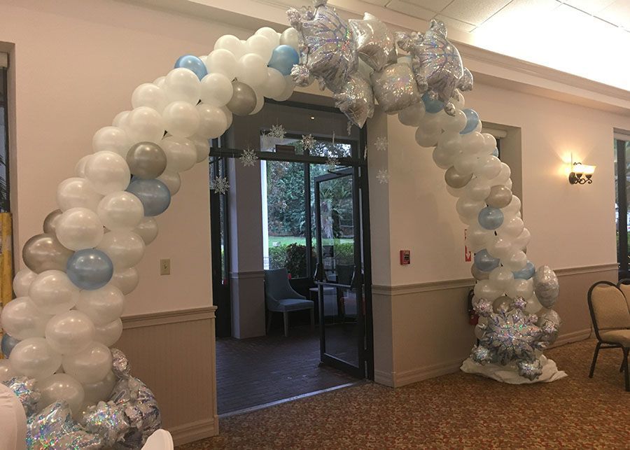 There is a balloon arch in the middle of a room.
