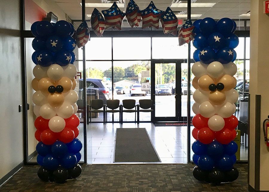 Two columns made of red white and blue balloons in a hallway