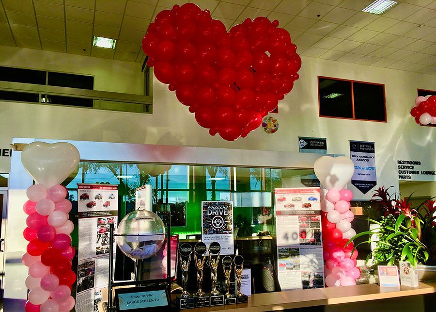 A heart shaped balloon is hanging from the ceiling