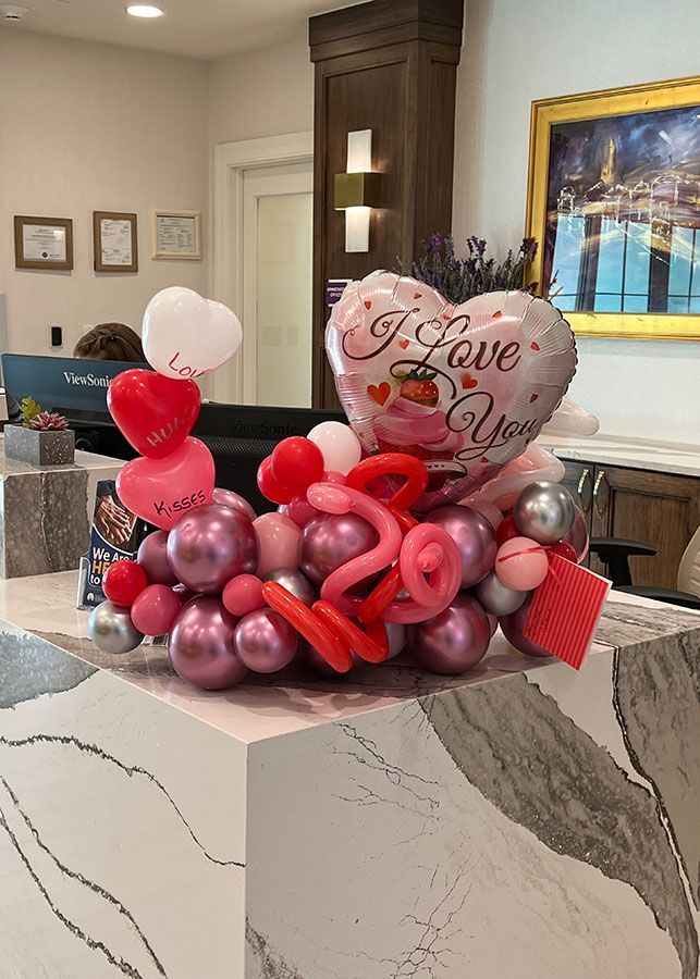 A bunch of balloons on a counter that say `` i love you ''