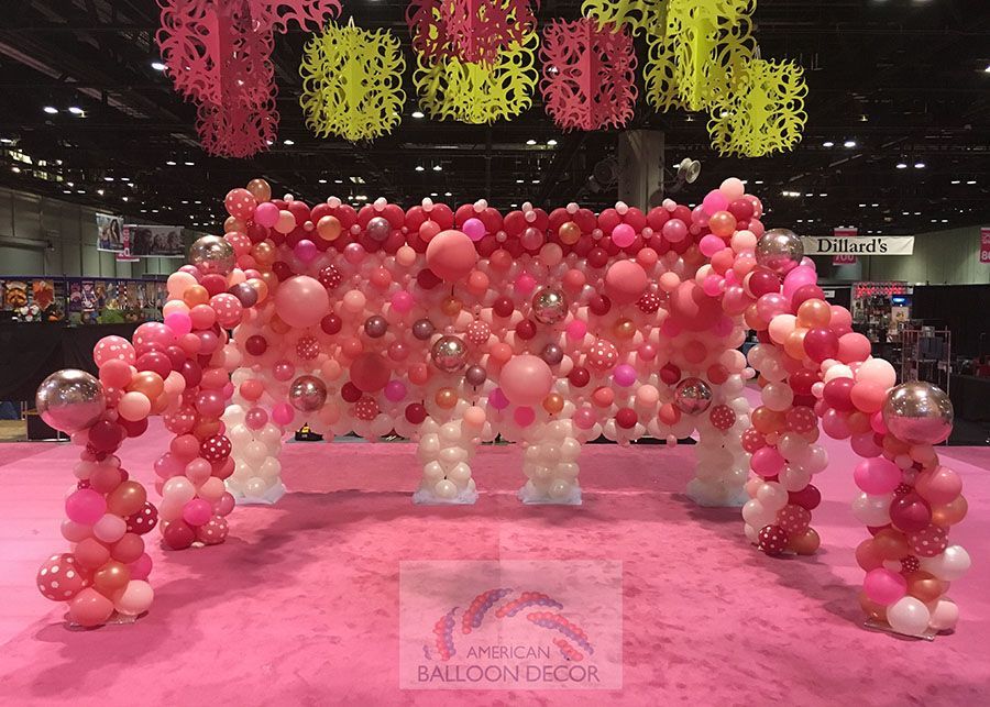 A large arch made of pink and white balloons