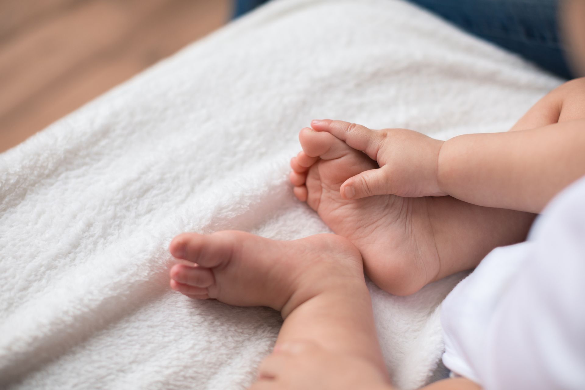 Un gros plan des pieds d'un bébé sur une couverture blanche.