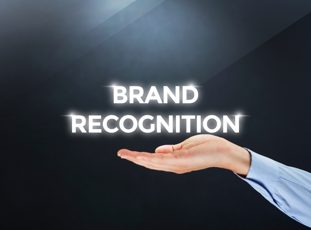 A hand is holding a sign that says brand recognition