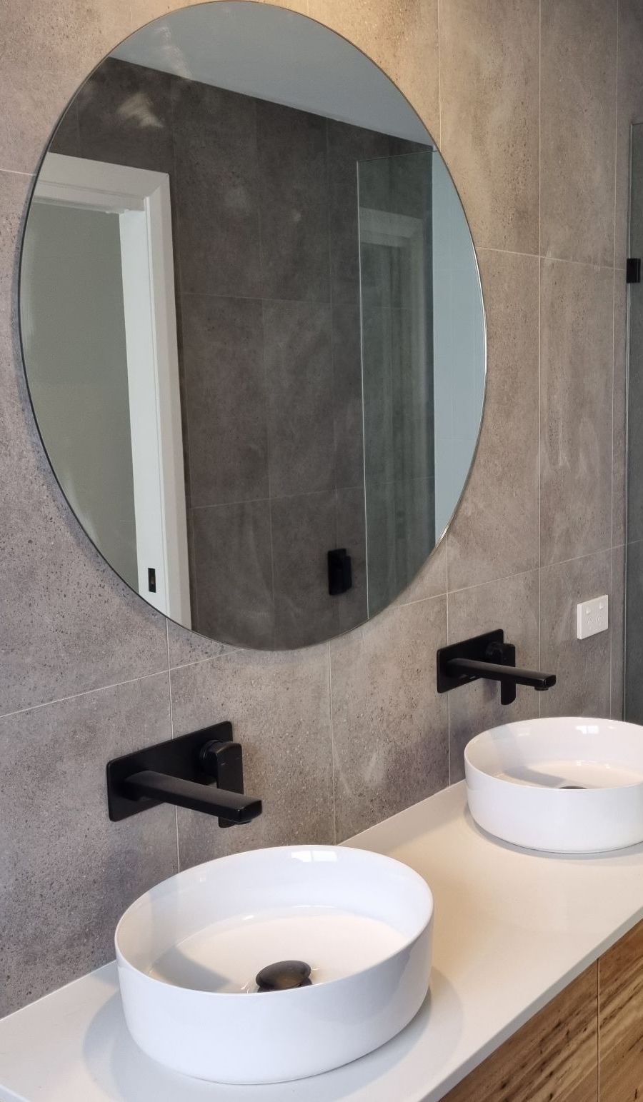 A Blue Car Is Driving Down A Street Next To A Concrete Pump Truck — Beach Breeze Building In Tumbi Umbi, NSW