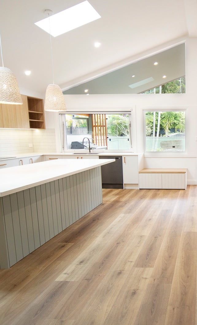 A Row Of White Trucks Are Parked In A Dirt Lot — Beach Breeze Building In Warnervale, NSW