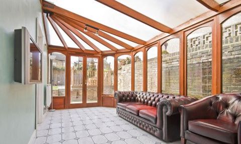 a stunning conservatory with wooden door and window frames