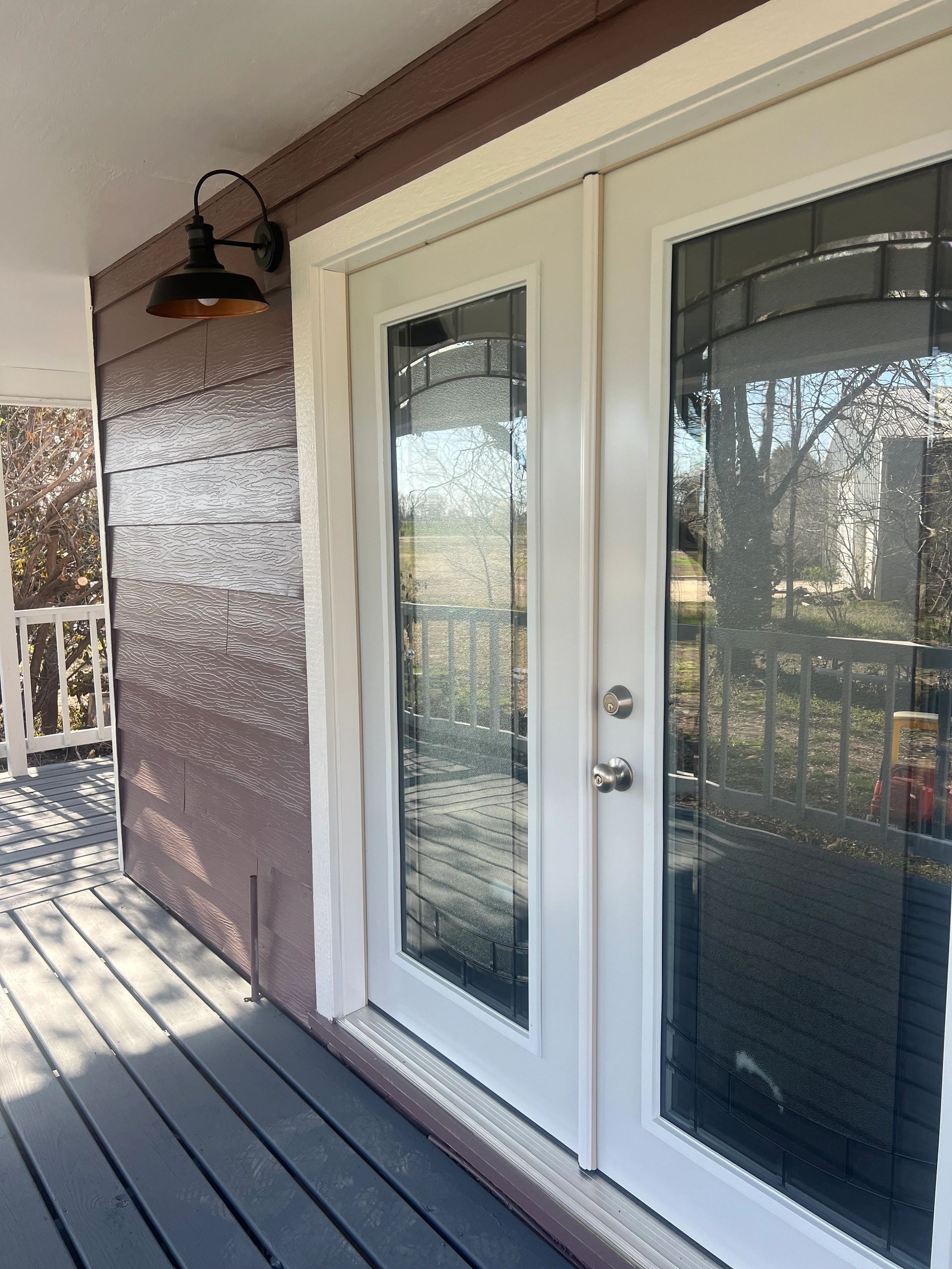 A white door with a reflection of a tree in it