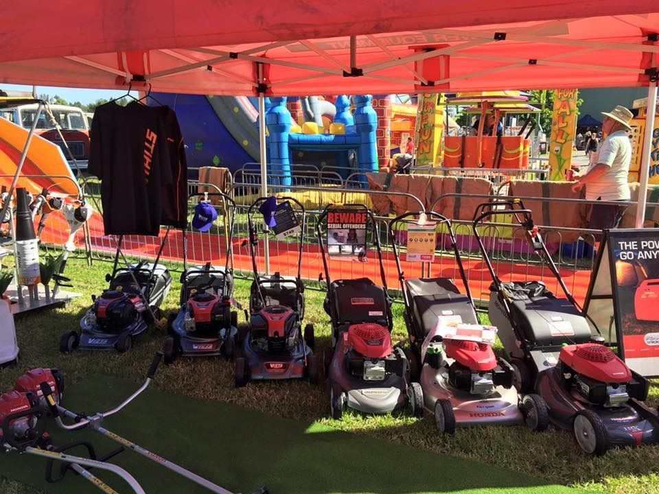 A Row Of Lawn Mowers Are Lined Up Under A Tent — Ken Matthews Auto & Mower Centre In Ulladulla, NSW