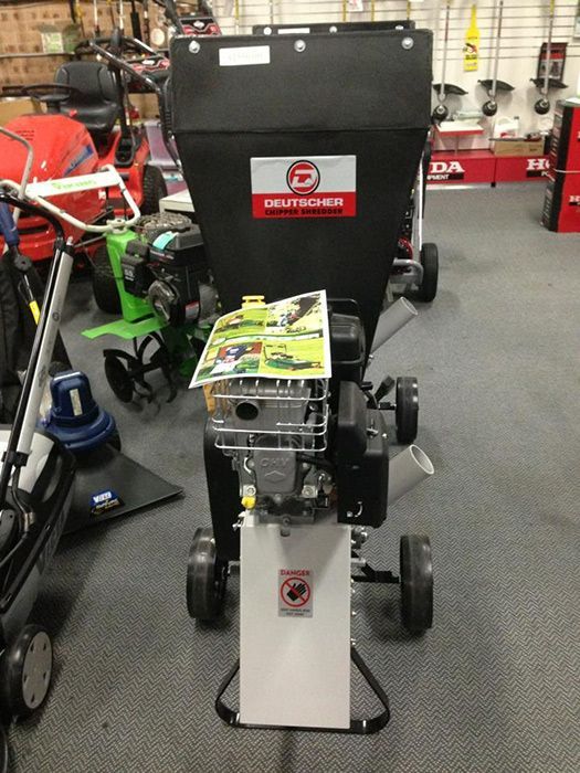 A Lawn Mower Is Sitting In A Store Next To A Shredder — Ken Matthews Auto & Mower Centre In Ulladulla, NSW