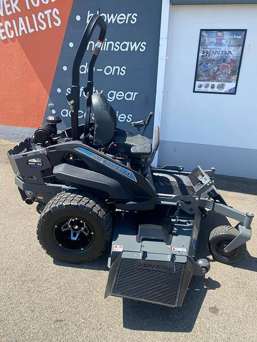 A Black And Gray Lawn Mower Is Parked In Front Of A Building — Ken Matthews Auto & Mower Centre In Ulladulla, NSW
