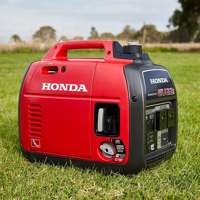 A Red Honda Generator Is Sitting In The Grass — Ken Matthews Auto & Mower Centre In Ulladulla, NSW