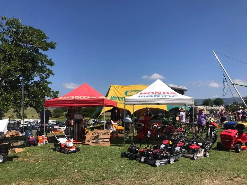 A Group Of People Are Standing In A Field In Front Of A Honda Tent — Ken Matthews Auto & Mower Centre In Ulladulla, NSW