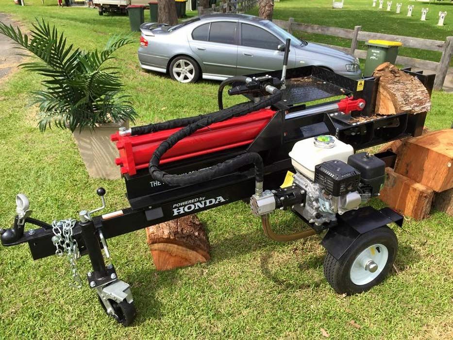 A Honda Log Splitter Is Parked In The Grass Next To A Car — Ken Matthews Auto & Mower Centre In Ulladulla, NSW