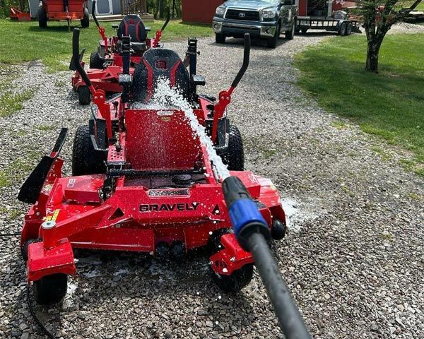 A Red Gravely Lawn Mower Is Being Sprayed With Water — Ken Matthews Auto & Mower Centre In Ulladulla, NSW