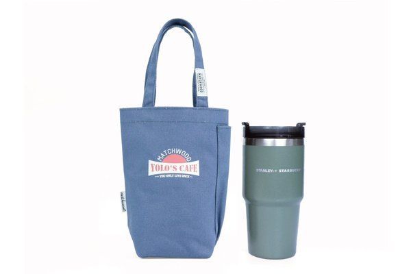 A blue tote bag and a green tumbler on a white background