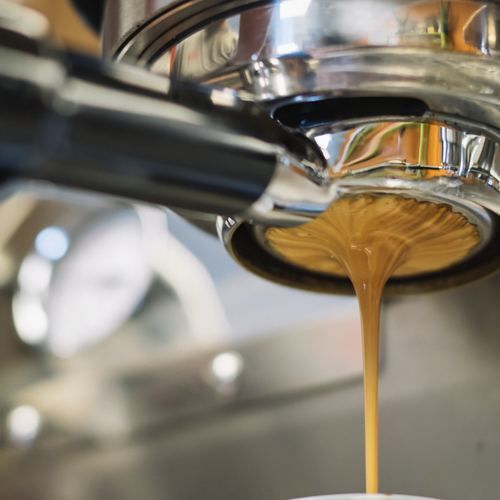 A close up of a coffee being poured into a cup