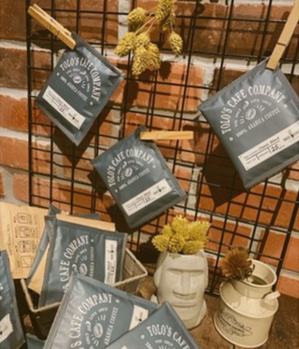 Several bags of tolo 's cafe company coffee hanging on a wall