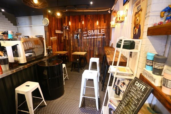 A coffee shop with tables and chairs and a sign that says smile.