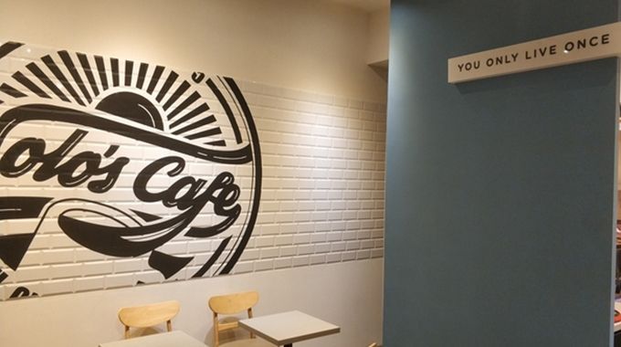 A wall with a logo for colo 's cafe painted on it.