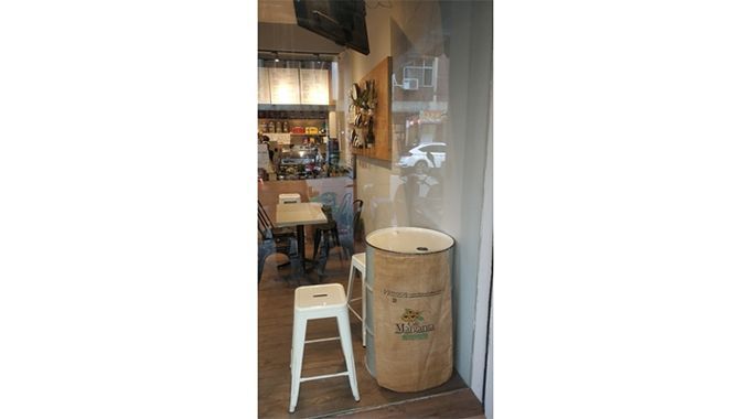 A wooden barrel is sitting in a room next to a table and stools.