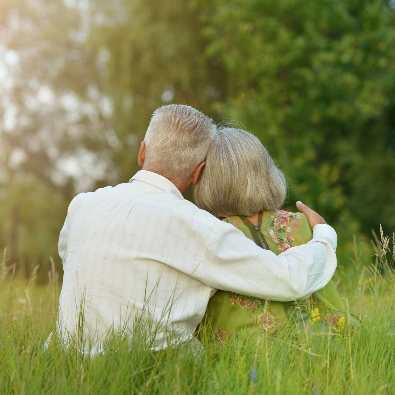 a man and woman walking on the beach holding hands