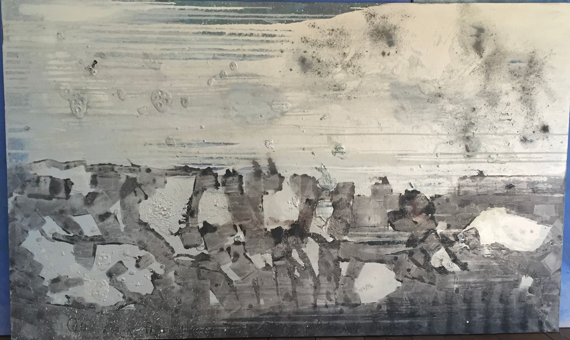 A black and white painting of a landscape is sitting on a table.