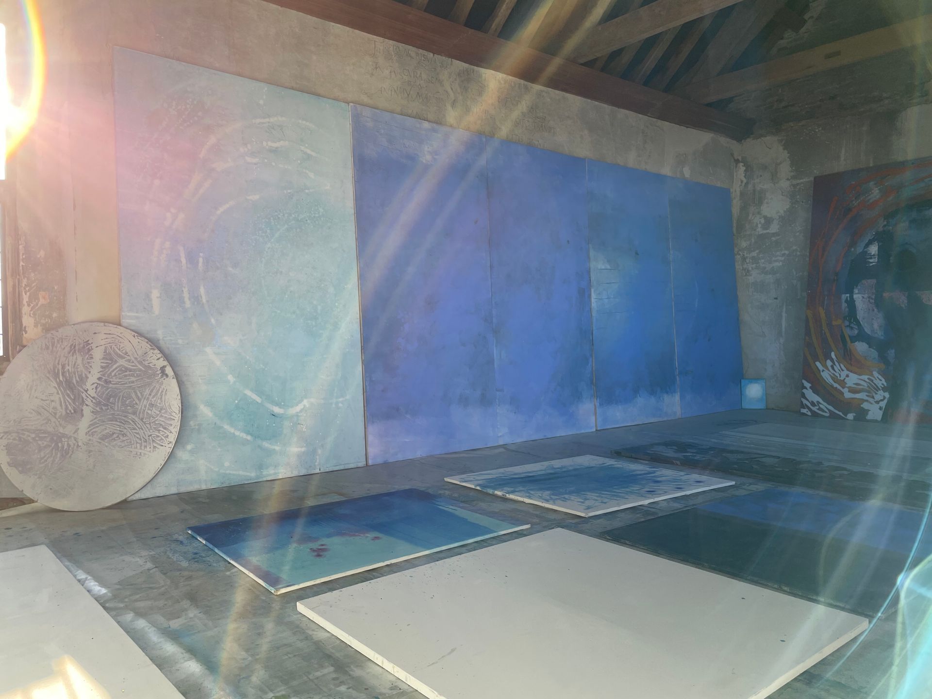 A room with a lot of blue paintings on the wall.