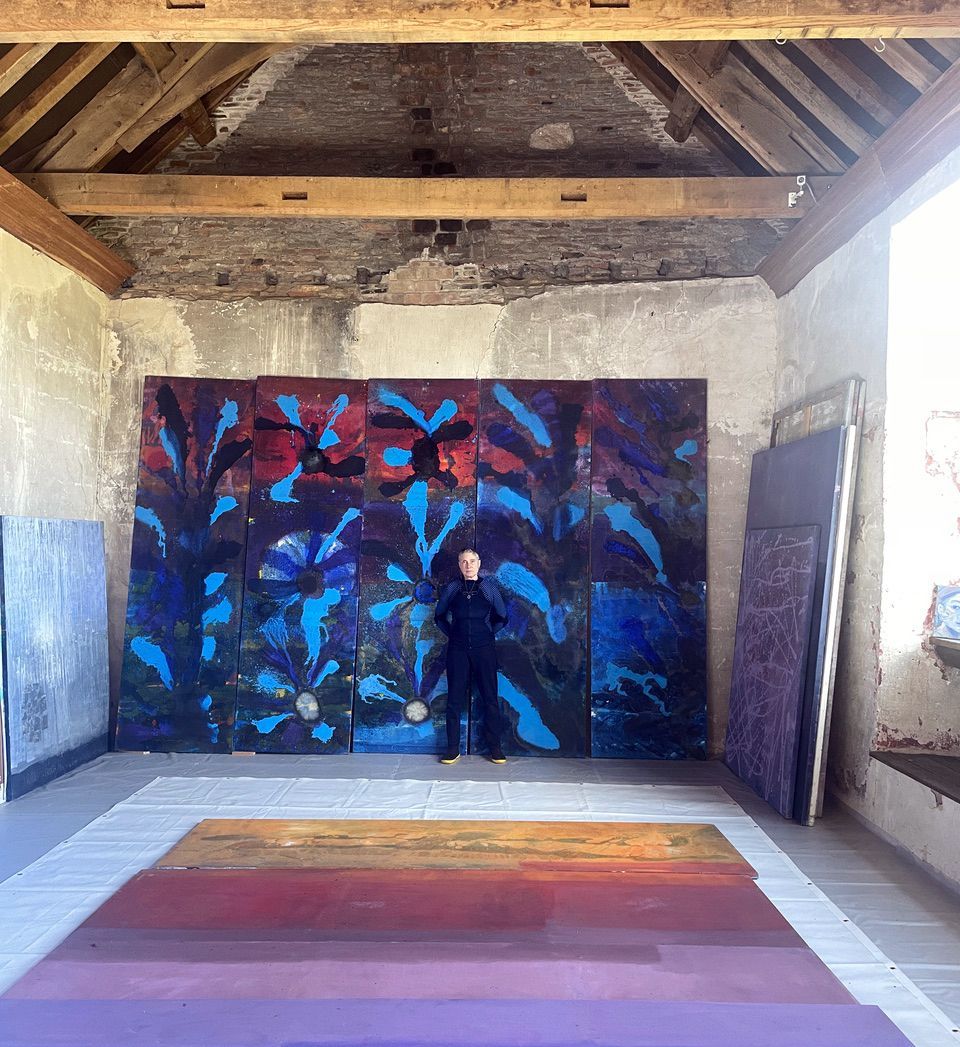 Artist standing in front of a large painting
