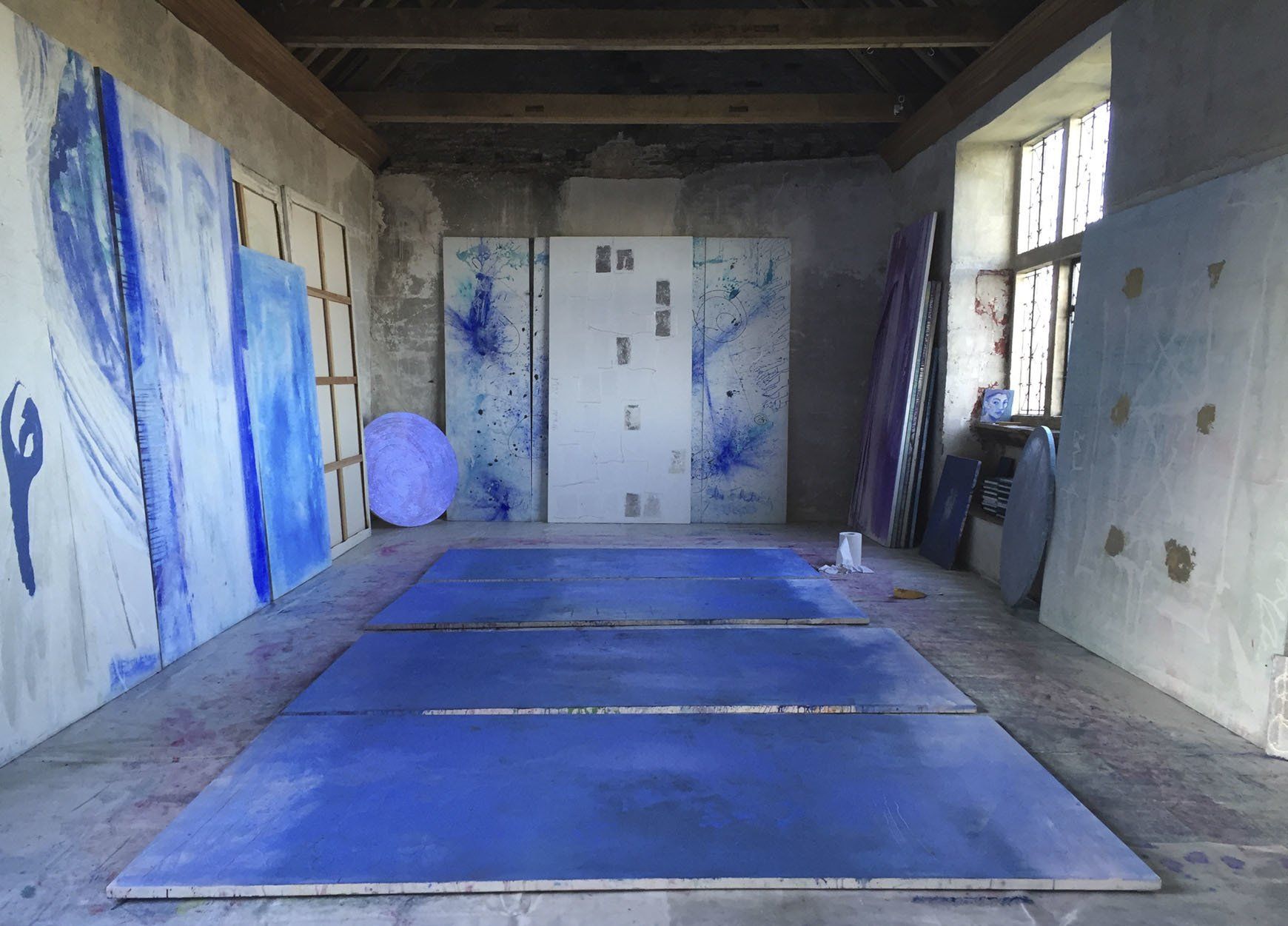 Gallery with a blue paintings on the walls.