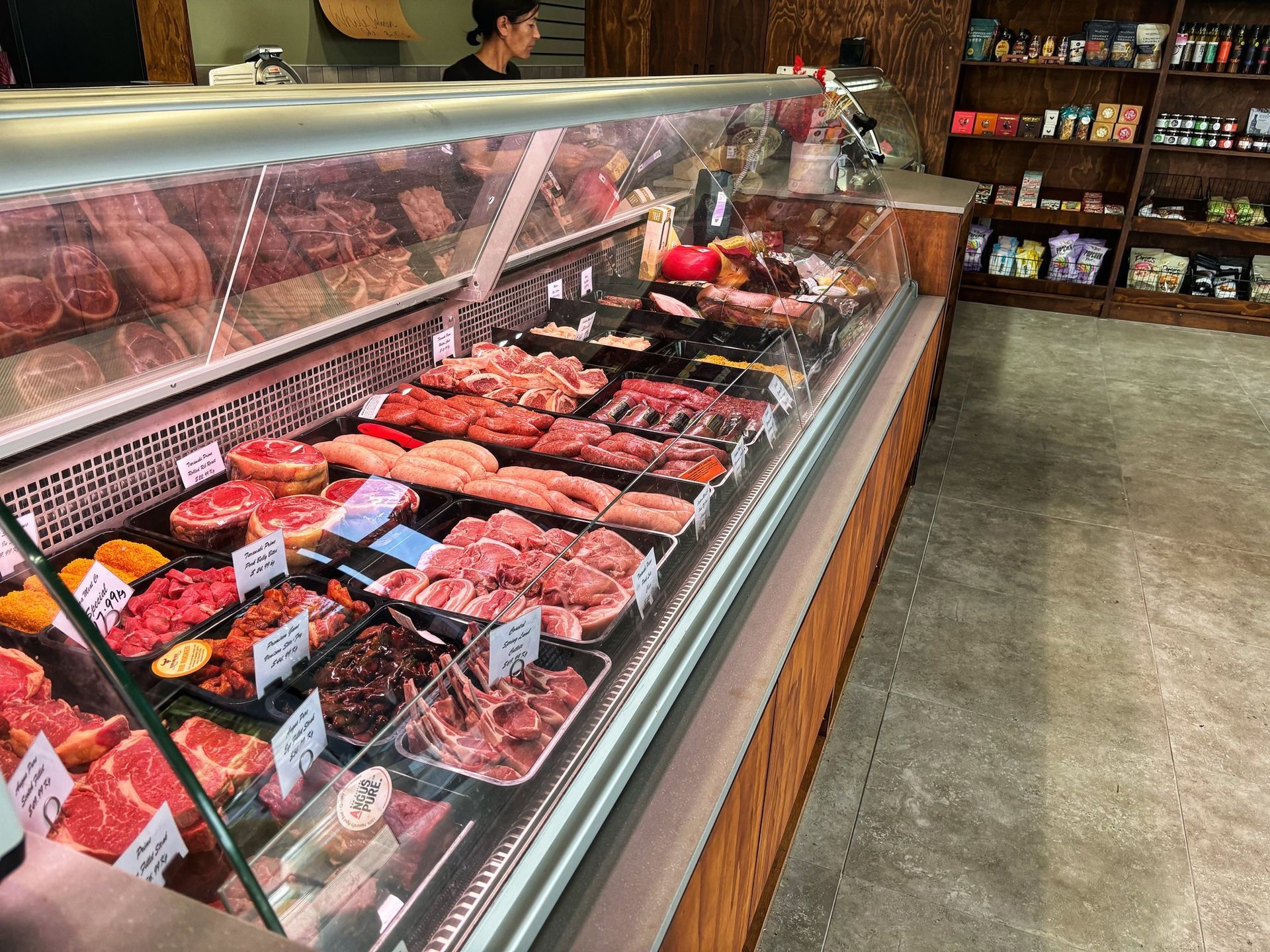 A display case filled with lots of meat in a butcher shop.