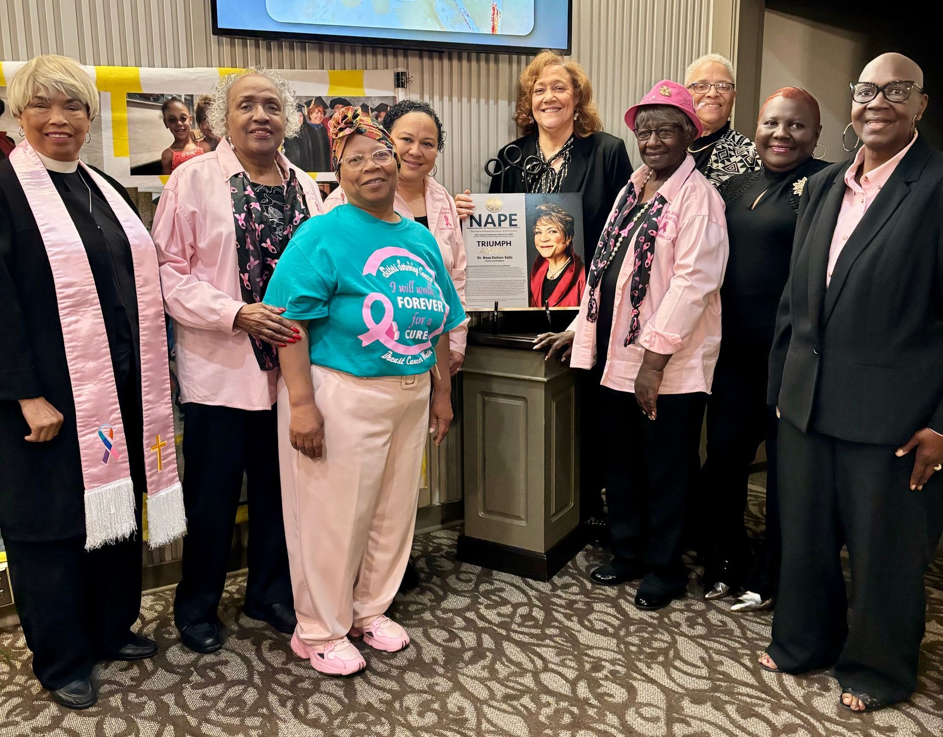 A group of women are posing for a picture in front of a podium.