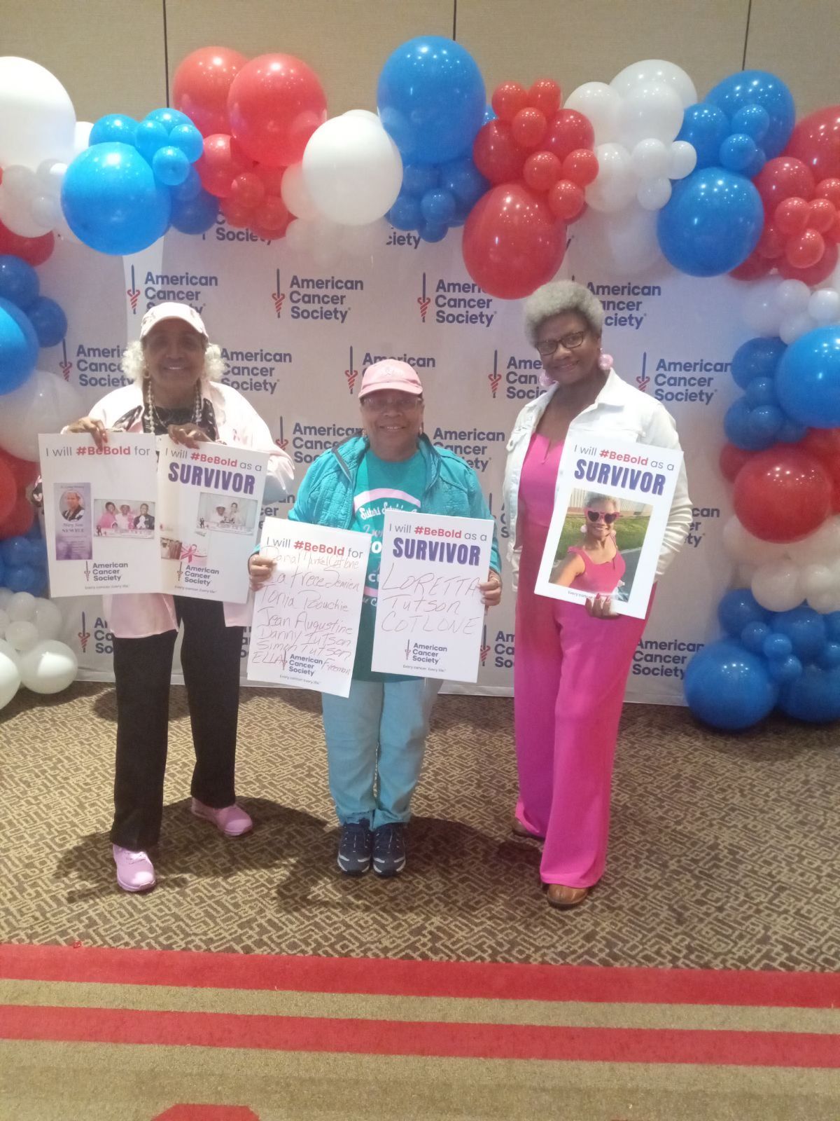 3 women wearing pink posing for a picture.