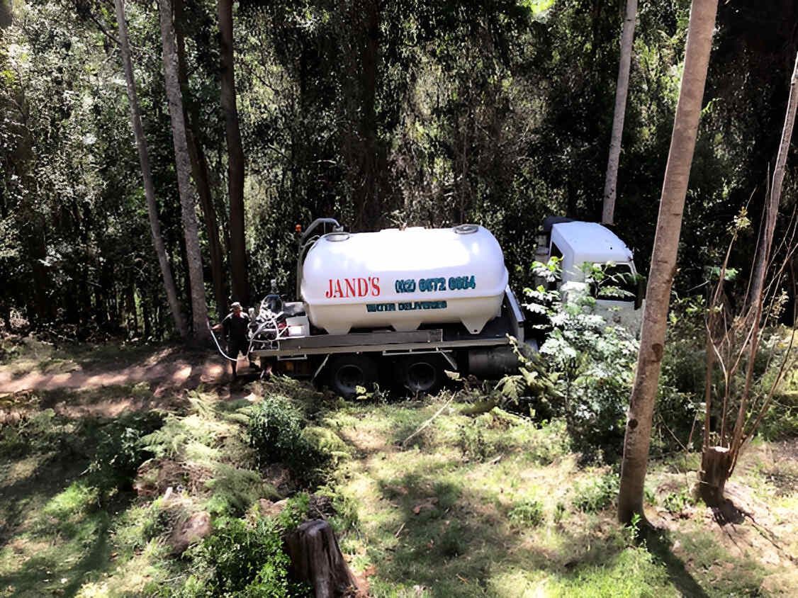 A Tanker Truck Is Parked In The Middle Of A Forest — Glass~a~Water In Eungella, NSW
