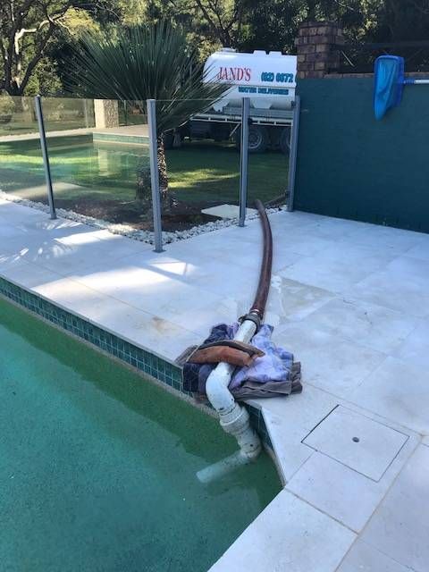 A hose is attached to the edge of a swimming pool