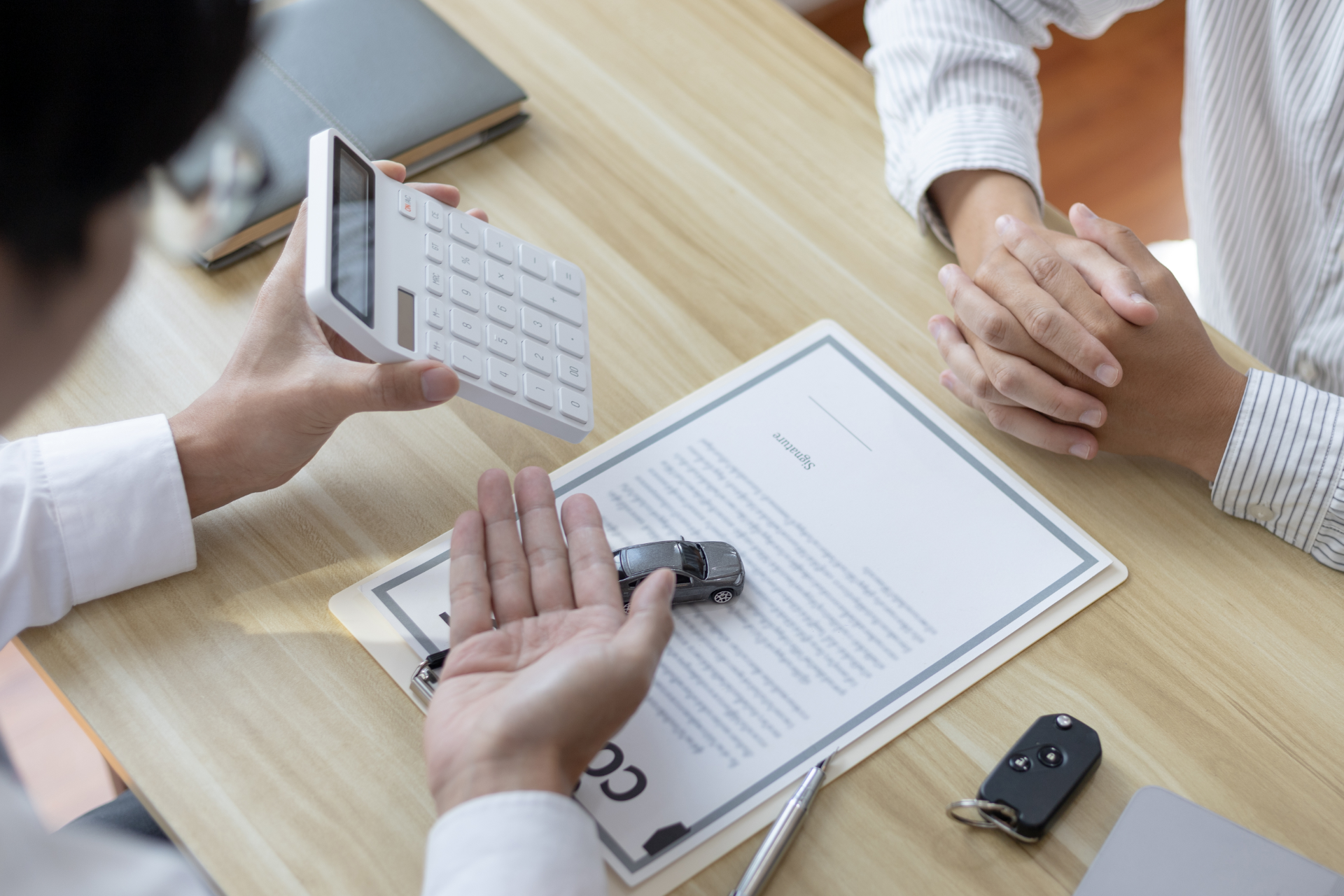 Semi-truck crashed on side of highway, being towed. White cab, trailer, orange cones, tow truck.