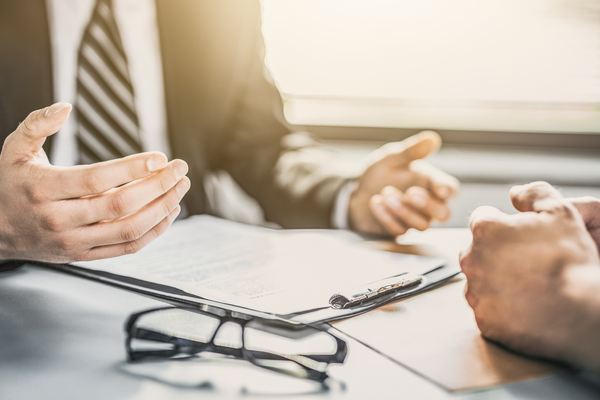 Semi-truck crashed on side of highway, being towed. White cab, trailer, orange cones, tow truck.