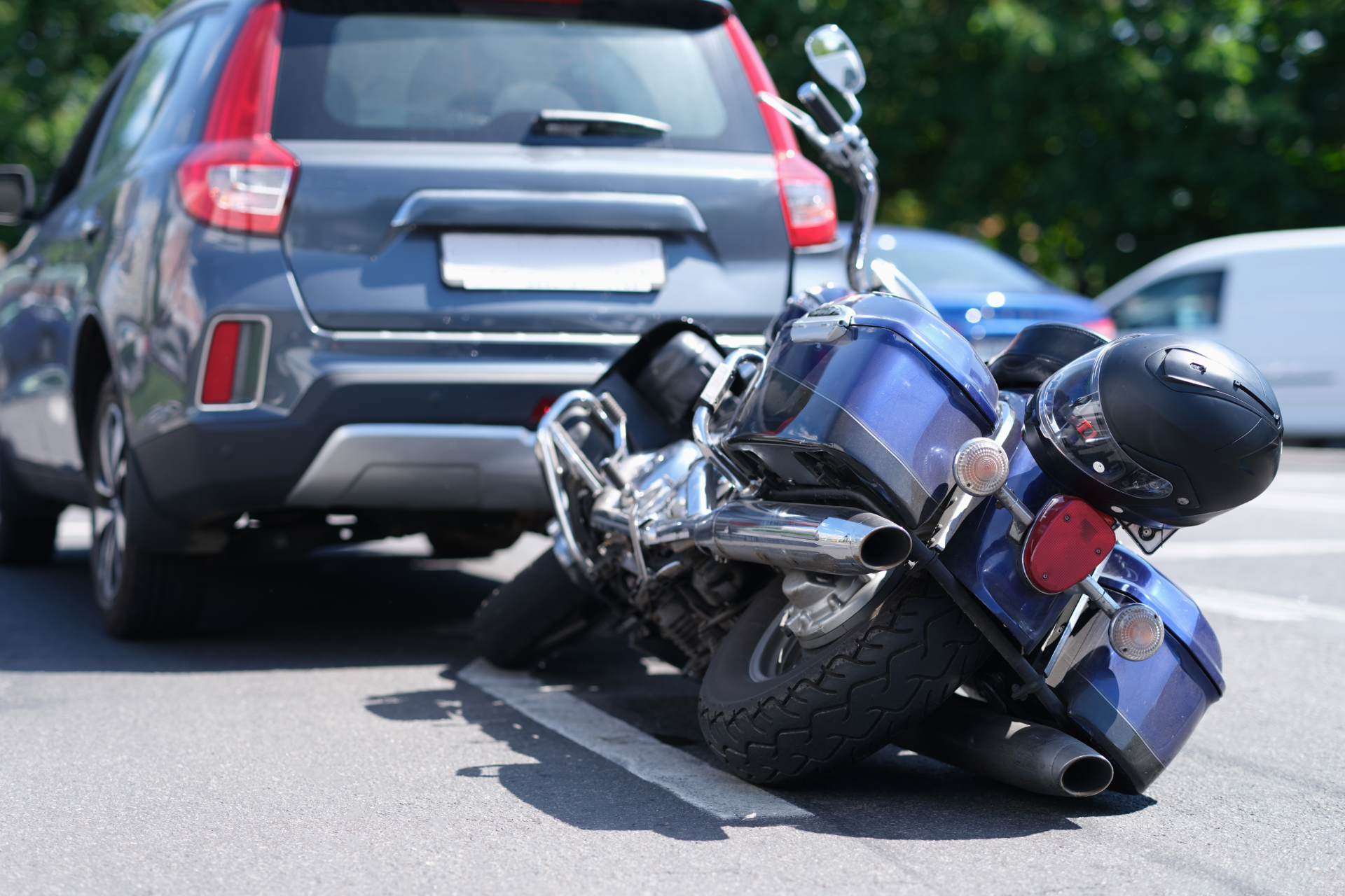Semi-truck and trailer crashed off road. People stand near wreckage, green field, blue sky.