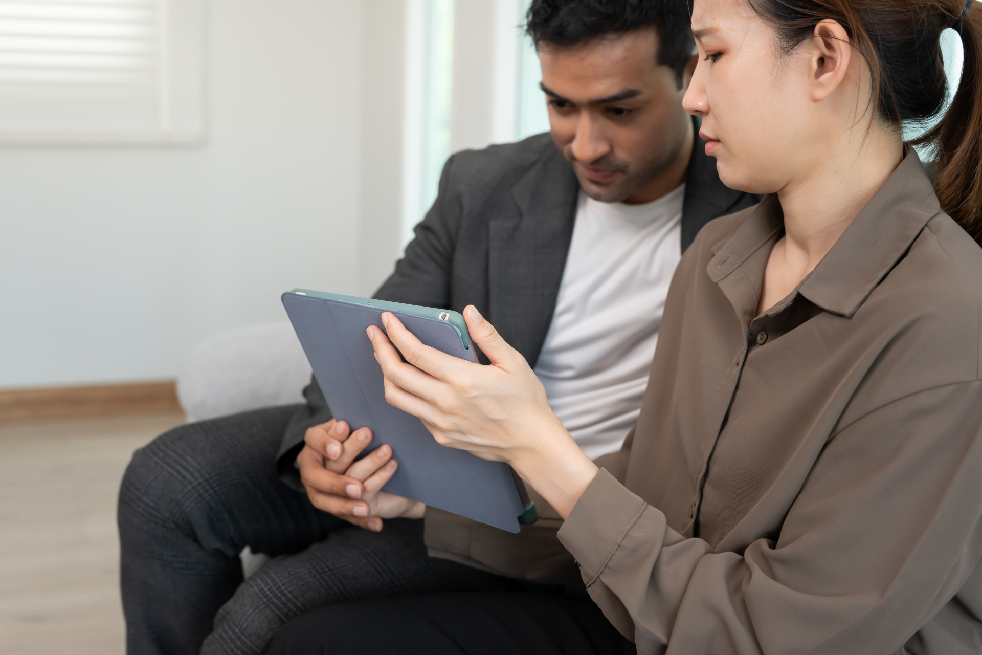 Semi-truck crashed on side of highway, being towed. White cab, trailer, orange cones, tow truck.