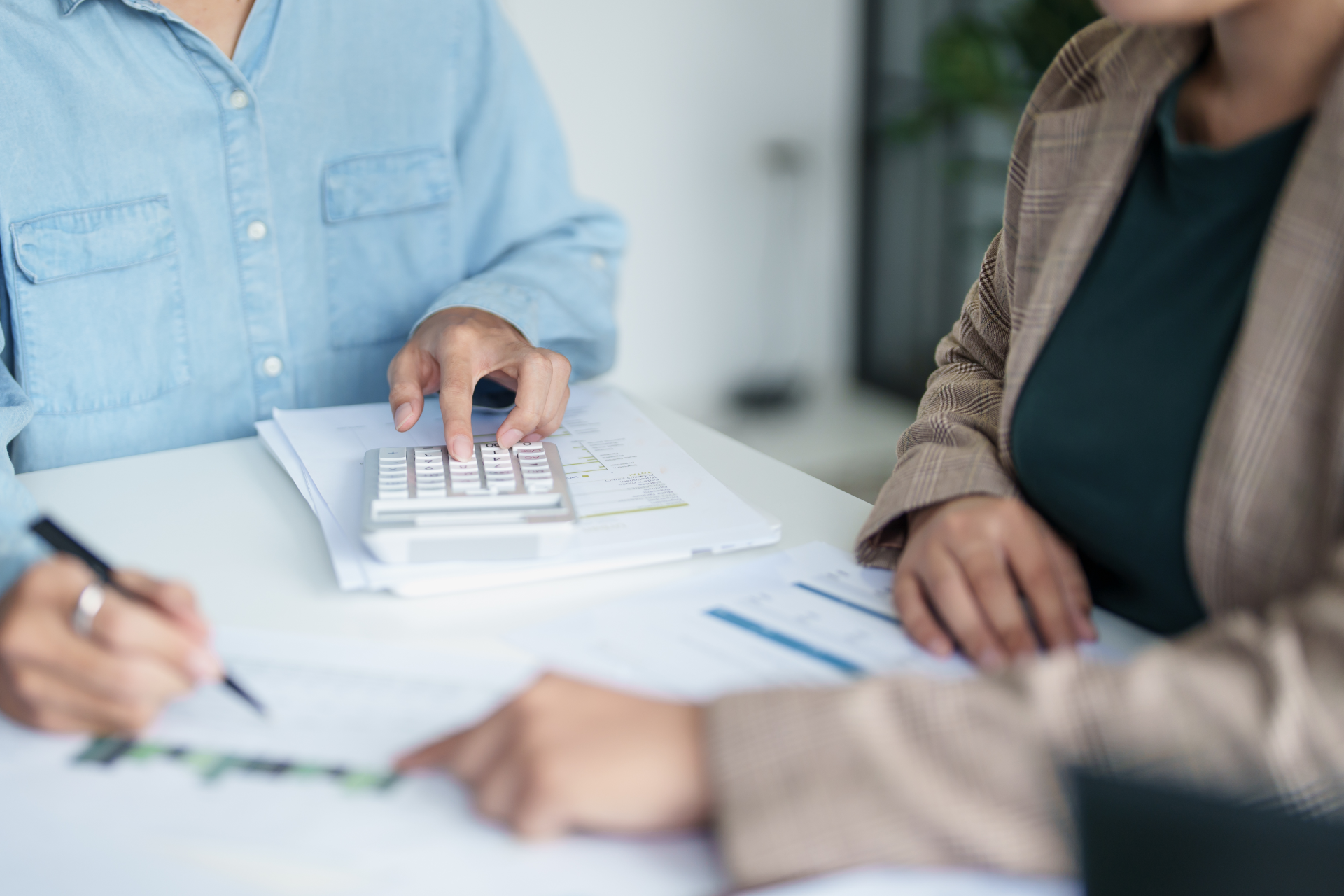 Semi-truck crashed on side of highway, being towed. White cab, trailer, orange cones, tow truck.